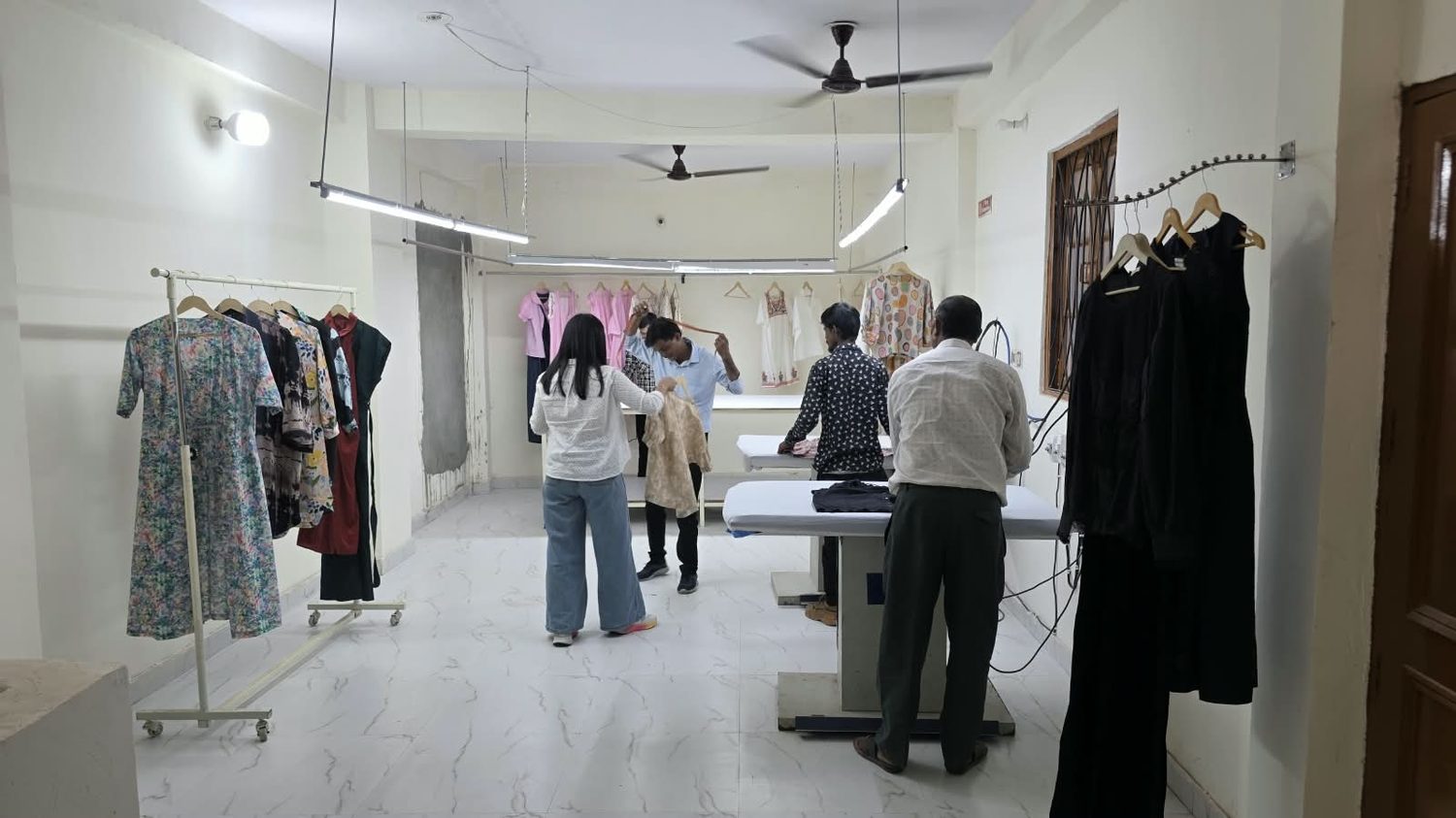 The finishing and pressing area with completed garments on rails.