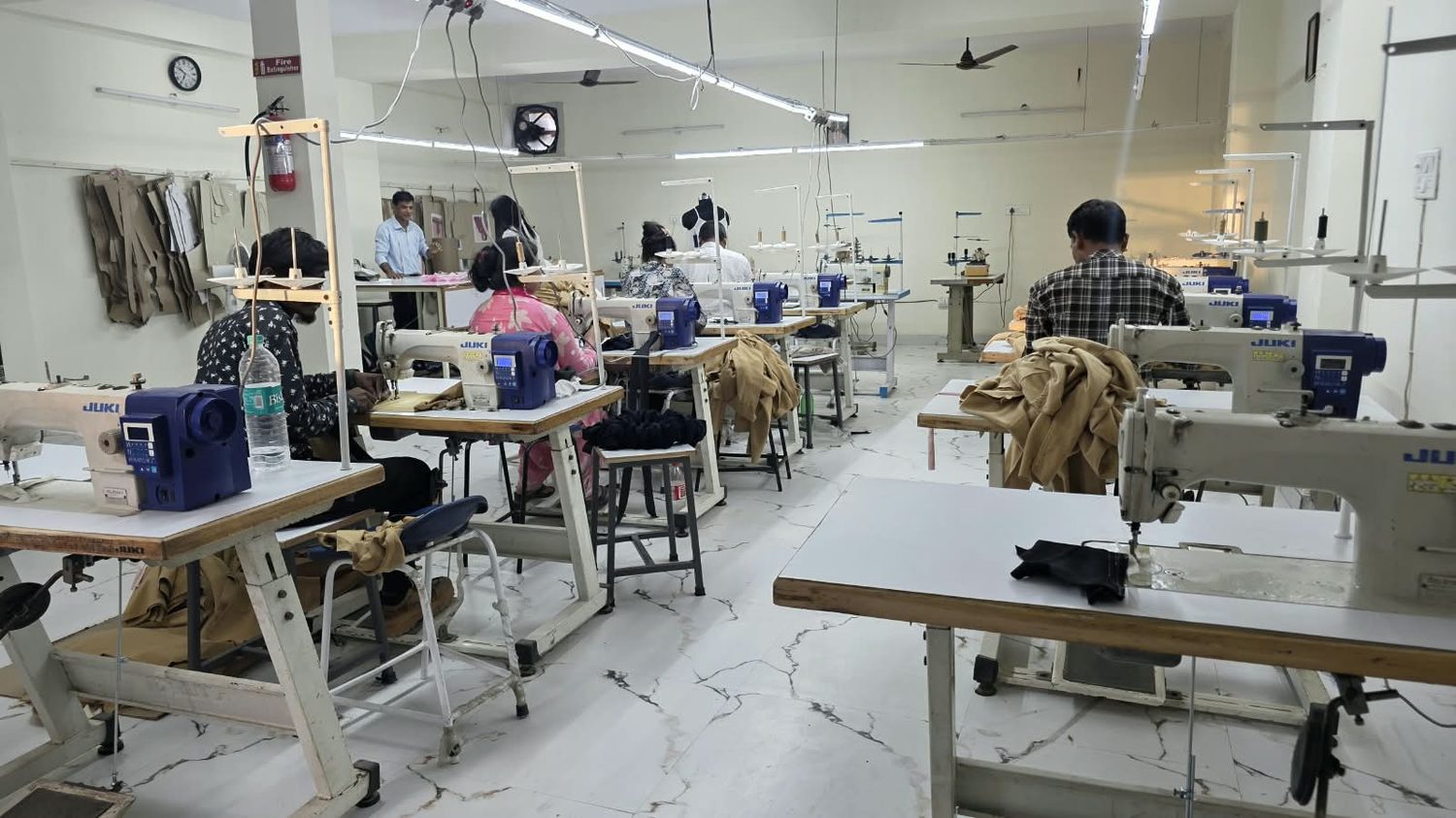 The stitching floor with operators working at Juki machines.